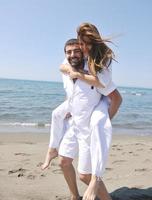 happy young couple have fun on beach photo