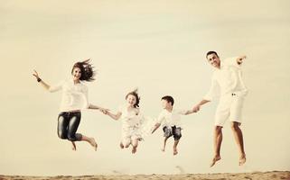 familia joven feliz divertirse en la playa foto