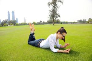 Beautiful young woman with  tablet in park photo