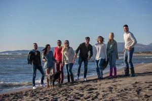 young friends jumping together at autumn beach photo