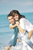 feliz pareja joven divertirse en la hermosa playa foto