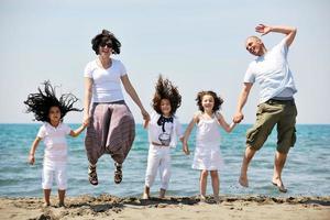 familia joven feliz divertirse en la playa foto