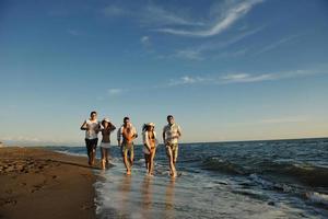 grupo de personas corriendo en la playa foto