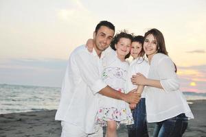 familia joven feliz divertirse en la playa foto