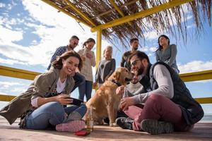 Group of friends having fun on autumn day at beach photo