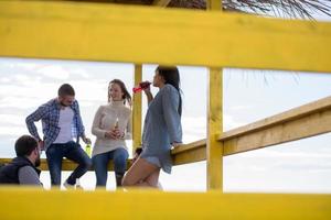 grupo de amigos divirtiéndose el día de otoño en la playa foto