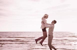 Loving young couple on a beach at autumn sunny day photo