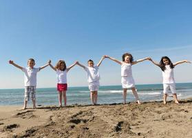 happy child group playing  on beach photo