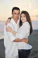 feliz pareja joven divertirse en la playa foto