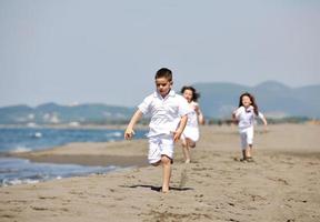 happy child group playing  on beach photo