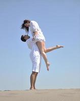 happy young couple have fun on beach photo