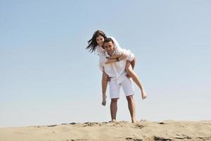 feliz pareja joven divertirse en la playa foto