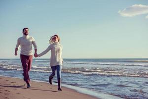 Loving young couple on a beach at autumn sunny day photo