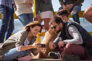 grupo de amigos divirtiéndose el día de otoño en la playa foto