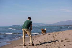 man with dog enjoying free time on the beach photo