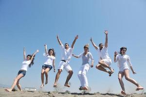 grupo de gente feliz divertirse y correr en la playa foto