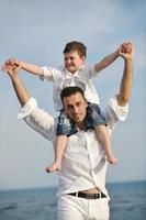 feliz padre e hijo se divierten y disfrutan del tiempo en la playa foto