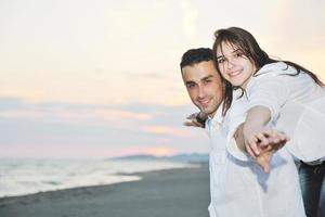 feliz pareja joven divertirse en la playa foto