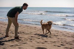 man with dog enjoying free time on the beach photo