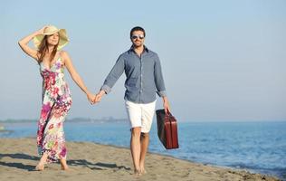 pareja en la playa con bolsa de viaje foto