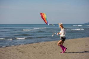 Young Woman with kite at beach on autumn day photo