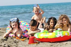 grupo infantil divertirse y jugar con juguetes de playa foto