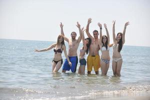 grupo de gente feliz divertirse y correr en la playa foto