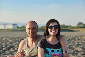 feliz pareja joven divertirse en la playa foto