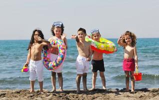 grupo infantil divertirse y jugar con juguetes de playa foto