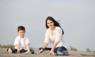 mom and son relaxing on beach photo