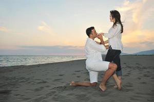 feliz pareja joven divertirse en la playa foto