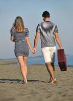 couple on beach with travel bag photo