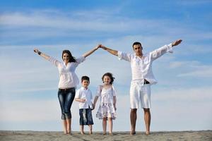 family on beach showing home sign photo