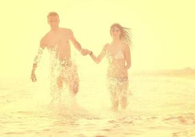 feliz pareja joven tiene tiempo romántico en la playa foto