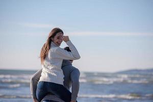 pareja divirtiéndose en la playa durante el otoño foto