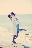 feliz pareja joven divertirse en la hermosa playa foto