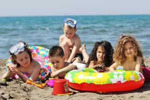 grupo infantil divertirse y jugar con juguetes de playa foto