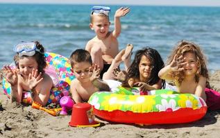 grupo infantil divertirse y jugar con juguetes de playa foto