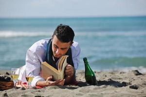 man reading book at beach photo