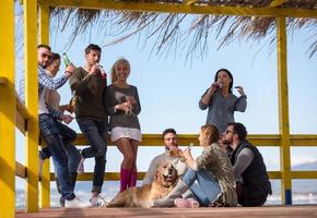 grupo de amigos divirtiéndose el día de otoño en la playa foto