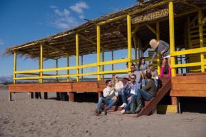 grupo de amigos divirtiéndose el día de otoño en la playa foto