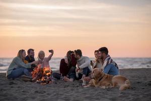 Friends having fun at beach on autumn day photo