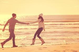 Loving young couple on a beach at autumn sunny day photo