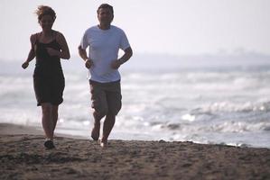 pareja corriendo en la playa foto