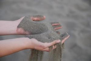 fine sand leaking trought woman hands photo