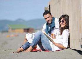 pareja joven disfrutando de un picnic en la playa foto