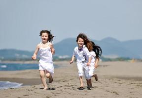 Grupo de niños felices jugando en la playa foto