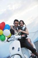 just married couple on the beach ride white scooter photo