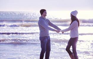 Loving young couple on a beach at autumn sunny day photo