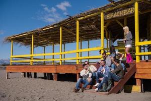 grupo de amigos divirtiéndose el día de otoño en la playa foto